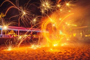 TropOut Phuket gay night party: fire show on the beach. Sparks fly as a performer spins a fiery circle. Gay travel advice.