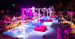 Xana Beach Club Phuket pool party. Night view of the pool with platforms and people. Gay travel advice for Thailand's top destinations.