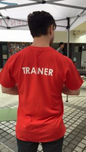 Back view of a man in a red TRAINER shirt at Pink Season, a gay event festival and gay pride event in Hong Kong.