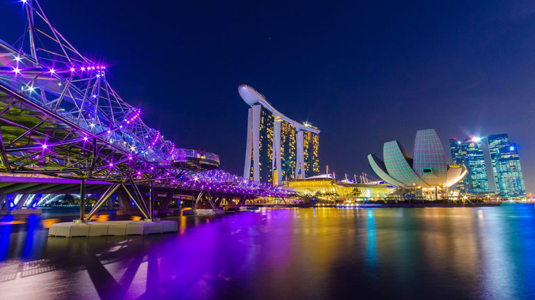 Singapore's skyline at night. Marina Bay Sands, ArtScience Museum, and Helix Bridge are illuminated. Gay Singapore Travel Guide.