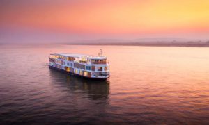 The Strand Cruise ship on the Irrawaddy River at sunset. A luxury gay-friendly cruise from Bagan to Mandalay in Myanmar. River cruise travel.