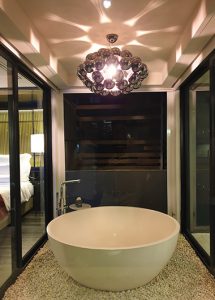 Akyra Manor Chiang Mai: Chic bathroom with tub, pebbles, and a modern chandelier. One of the best gay hotels in Nimman, Chiang Mai.