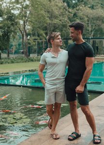 Gay couple at Anantara Chiang Mai Resort, popular honeymoon hotel. Two men by a koi pond, enjoying a romantic getaway. Thailand travel.