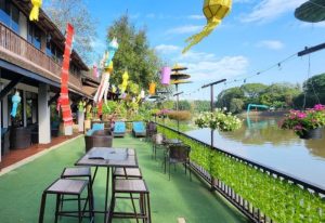 Club One Seven Gay Men Hotel's riverfront patio. Tables, chairs, and colorful lanterns create a relaxing atmosphere at this gay-friendly hotel.
