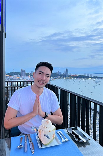 Gay traveler enjoying a coconut at Hilton Pattaya, a beachfront hotel near CentralFestival Pattaya Beach. Perfect gay travel destination.