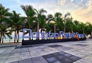 Dongtan Beach Pattaya sign. Tropical gay travel destination. Palm trees, sunset. Popular with gay men. Thailand beach vacation.