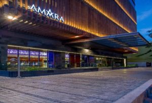 Amara Bangkok Hotel entrance at dusk. Gay-friendly hotel with modern design. Ideal for gay travelers seeking comfort in Bangkok, Thailand.