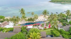 Aerial view of Anantara Lawana Koh Samui Resort, a gay-friendly hotel. Palm trees, pool, beach, and boats visible. Tropical paradise.