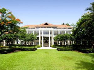Centara Grand Beach Resort Samui facade. Gay-friendly hotel with manicured lawn and tropical trees. Ideal for gay men's travel in Samui, Thailand.