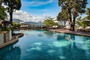 Poolside view at Centara Villas Phuket Hotel, a gay-friendly resort. Loungers line the deck overlooking the sea. Perfect for gay travel.