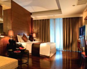 FuramaXclusive Sathorn Hotel Bangkok room. Gay-friendly hotel with modern design, wood accents, and warm lighting. Comfortable stay in Bangkok.