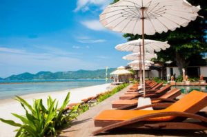 Montien House Hotel's beach view. Gay-friendly hotel with beach umbrellas and lounge chairs. Perfect for gay travel and relaxation.