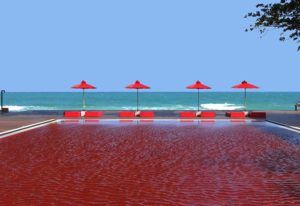 The Library Hotel's unique red pool. Beachfront gay-friendly hotel with red umbrellas. A great place for gay men to relax and enjoy the view.