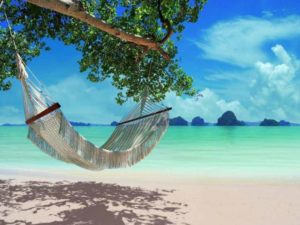 Hammock at The Tubkaak Krabi Boutique Resort, a gay-friendly hotel. Beach view, turquoise water, islands in background. Relaxing vacation.