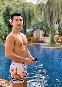Gay traveler at Holiday Inn Resort Phuket. Man in floral swim trunks by the pool. Gay Phuket resort for gay travelers. Gay travel.