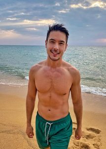 Gay man at Renaissance Phuket Resort & Spa, Mai Khao Beach. Luxury travel destination. Quiet beach, turquoise water, and a handsome man.