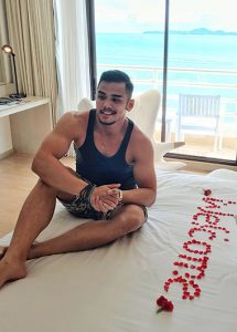 Gay man at Pullman Pattaya Hotel G, a luxury hotel. Welcome message on bed in roses. Ocean view. Best gay hotel in Pattaya.