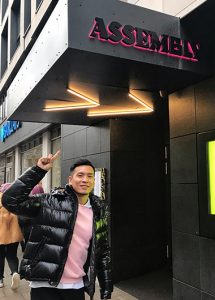 Assembly Hotel, London. Man points to the entrance of this most booked gay hotel in London's city center. A great gayborhood choice.