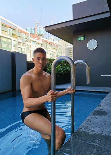 Gay Singapore hotel: Muscular man exiting pool at InterContinental Singapore Robertson Quay. Private luxury travel for gay men. Cheap hotel.