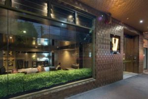 Facade of Gay-Friendly Hotel 57 Hotel. View through the window with people inside. Modern design, welcoming atmosphere.