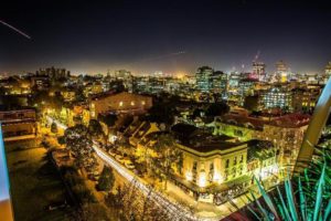 Night view of ADGE Apartments, a gay-friendly hotel. Cityscape with illuminated buildings. Ideal for gay travelers seeking stylish stays.