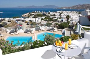 Ilio Maris gay-friendly hotel view. Mykonos town, pool, windmills, sea. Gay travel destination. Balcony with breakfast.