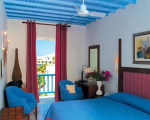 Poseidon Hotel Suites gay-friendly room. Balcony view, blue accents, modern design. Pet-friendly hotel for gay travel. Mykonos suites.