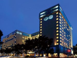 Night view of the Sheraton Grand Taipei Hotel, a gay-friendly hotel in Taipei. Lit windows and logo on the building's facade.