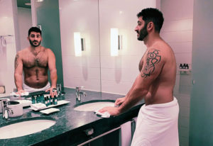 Gay-friendly hotel: Man with tattoo in towel in bathroom at Sofitel Berlin Kurfurstendamm Hotel. Pet-friendly hotel in Berlin.