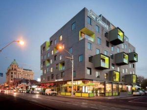 The Cullen Melbourne Art Series Hotel exterior. Gay-friendly hotel with unique architecture. Melbourne travel. Modern design with green accents.