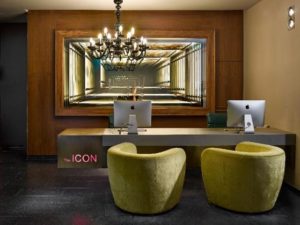 The Icon Hotel and Lounge reception area. Gay-friendly hotel features modern design, chandelier, and stylish seating.