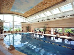 Indoor pool at the gay-friendly Radisson Collection Hotel Xing Guo, Shanghai. Relaxing swimming area with lounge chairs and natural light.