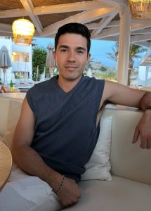Gay traveler at Andronikos Hotel, Mykonos. Man relaxing near gay bars. Popular gay hotels offer stylish comfort, perfect for gay travel.