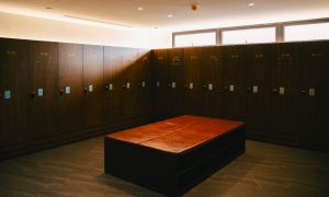 Locker room at a popular gay sauna in Seoul. Rows of dark wood lockers line the wall, with a bench in the center. Travel advice for gay men.