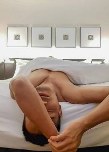 Man relaxing at The Resident Soho, a best gay hotel in London. Gay travel advice for Soho, London. Hotel room with modern art.
