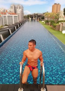 Holiday Inn Express Singapore Clarke Quay rooftop pool. Fit Asian man in swim briefs. Best gay hotels in Singapore City Center gayborhood.