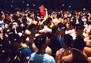 Gay Shanghai nightlife: ANGEL Shanghai presents HEAVEN. Crowd of shirtless Asian men, one holding a red fan, at a gay club event.