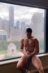 Gay man at Pullman Sydney Hyde Park hotel. Close to gay bars. Sydney skyline view. Best gay hotels in Sydney. Gay travel advice.
