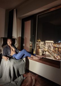 Hotel Clark Budapest: Gay man in room overlooking the Chain Bridge at night. Best gay hotels in Budapest's gayborhood.
