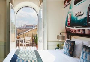 Hotel Indigo Rome St. George room with balcony. Top gay hotels Rome city center, featuring a bed and a view of the city.