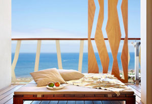 Bohemia Suites & Spa Adults Only luxury gay honeymoon hotel in Gran Canaria. Balcony view with daybed, pillows, fruit, and ocean vista.