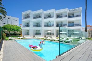 Atlantic Sun Beach Hotel, gay men only. Pool with unicorn float, loungers, and white building. Gay-friendly hotel for gay travelers.