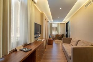Continental Hotel room interior. Gay-friendly hotel with modern décor, sofa, desk, TV, and natural light. Ideal for gay men travel.