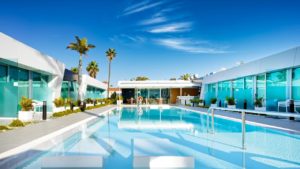 Hotel Nayra Adults Only pool view. Gay-friendly hotel with modern architecture, palm trees, and a clear blue sky. Ideal for gay travel.