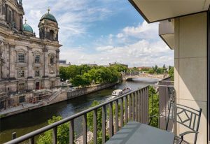 View from a Radisson Collection Hotel, Berlin balcony. River Spree, Berlin Cathedral, and boat visible. Gay-friendly hotel.