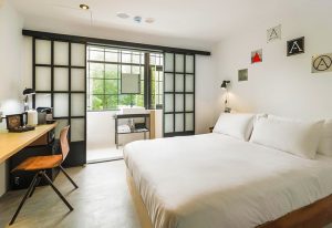 Art'otel Ximending Taipei room. Gay-friendly hotel with a bed, desk, and balcony. Modern design in Taipei, Taiwan. Great for gay travel.