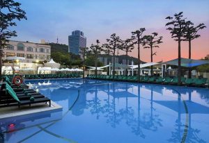 Banyan Tree Club & Spa Seoul pool. Gay-friendly hotel with outdoor pool, lounge chairs, and parasols. Relaxing spa and club experience. Seoul travel.