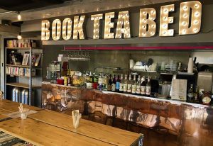 Book Tea Bed SHINJUKU-GYOEN's bar area. Gay-friendly hotel interior with books, tea, and beds. Cozy, inviting space.
