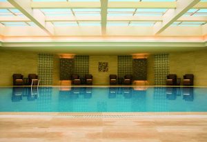 Indoor pool at the gay-friendly Courtyard by Marriott Shanghai Xujiahui hotel. Lounge chairs line the pool's edge, under a skylight.