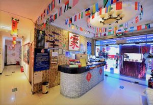 Happy Dragon Backpackers Hostel reception. Gay-friendly hotel with flags, Asian decor, and a welcoming atmosphere. Travel advice for gay men.